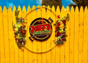 Jeff's Jamaican Cuisine Logo on a wooden entrance