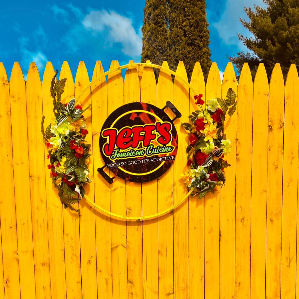 Jeff's Jamaican Cuisine Logo on a wooden entrance