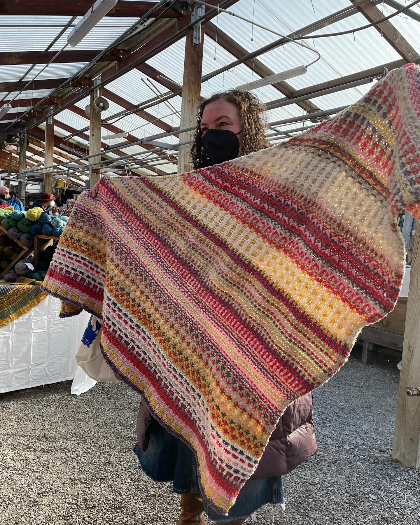 Lady holding a Substantial shawl knit made with our yarn