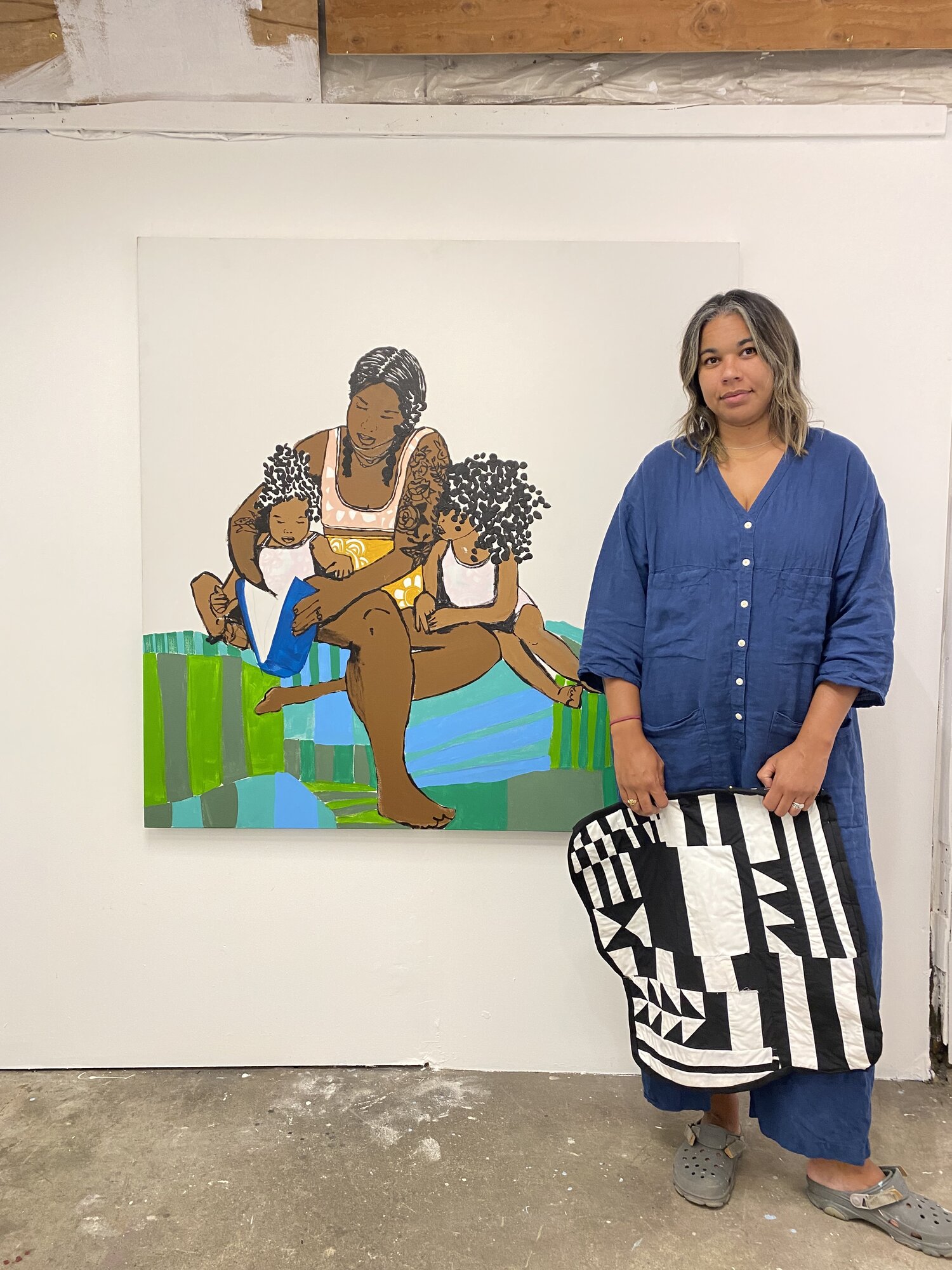 Rachel Gloria Adams standing beside her artwork